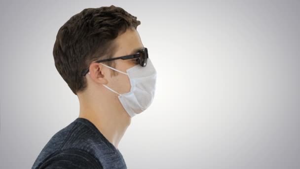 Cego homem andando em máscara médica e óculos escuros no fundo gradiente . — Vídeo de Stock