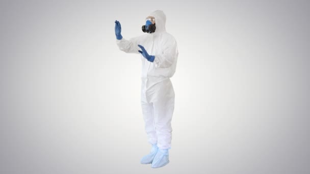 Scientist in protective suit and respirator pointing futuristic screen on gradient background. — Stock Video