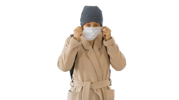 Femme blonde marchant et mettant la protection du visage en prévention du coronavirus covid 19 sur fond blanc . — Photo