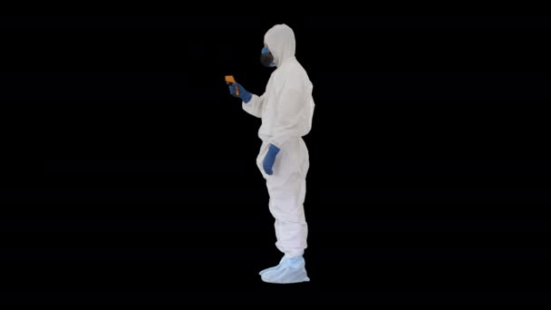 Врач носить защитную одежду с помощью инфракрасного термометра лба, чтобы проверить температуру тела на наличие симптомов вируса, Альфа-канал — стоковое видео