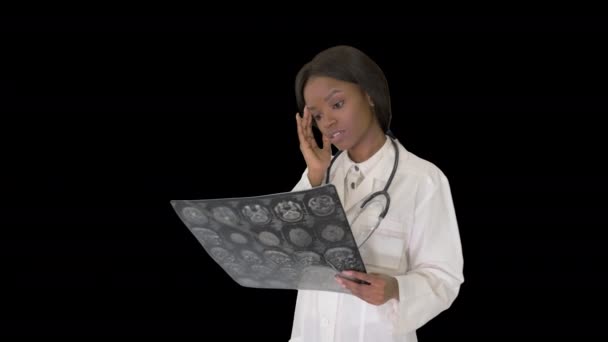 Jeune femme médecin debout regardant la radiographie d'un cerveau, Canal Alpha — Video