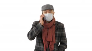 Beyaz arka planda yürüyen ve konuşan koruyucu maskeli şık bir erkek..