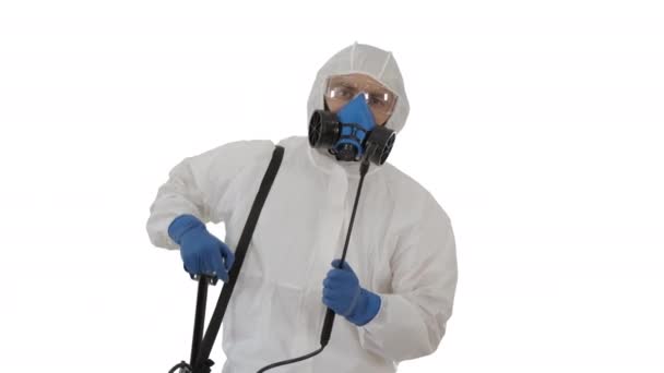 Hombre con un traje de equipo de protección personal, guantes, máscara y protector facial listo para desinfectar sobre fondo blanco . — Vídeo de stock