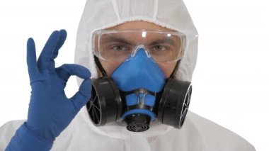 Koruyucu kıyafetli doktor her şeyin yolunda olduğunu beyaz arka planda gösterecek..