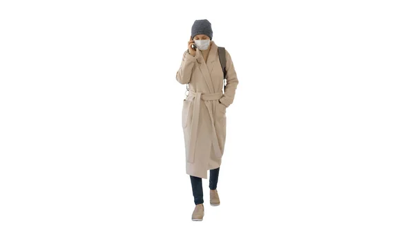 Jonge vrouw in beschermende masker lopen en praten door mobiele pho — Stockfoto