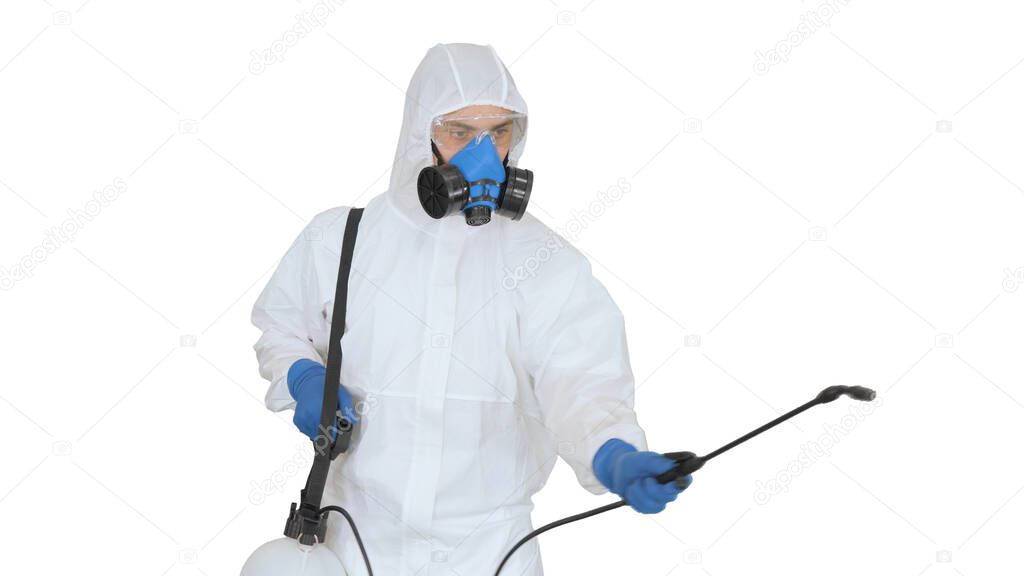 Man in a hazmat walking in and using disinfectant on white backg