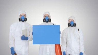 Koruyucu üniformalı bir grup epidemiyoloji uzmanı, gradyan arka planda boş plaket tutuyor..