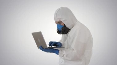 Koruyucu kıyafetli doktor dizüstü bilgisayarda çalışıyor ve değişken arka planda iyi sonuçlar elde ediyor..