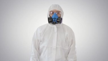 Koruyucu giysiler içindeki erkek doktor taraf tutuyor. Arkaplanda karantina kuralları var..