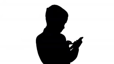 Şık takım elbiseli genç çocuk cep telefonuyla oynuyor..