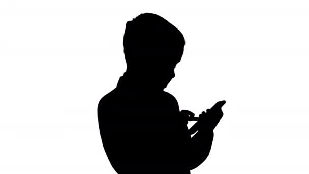 Silhouette Young boy in elegance suit playing with mobile phone. — Stock Video