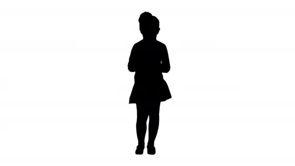 Silhouette Cute little girl looks in smartphone and writing a message. — Stock Video