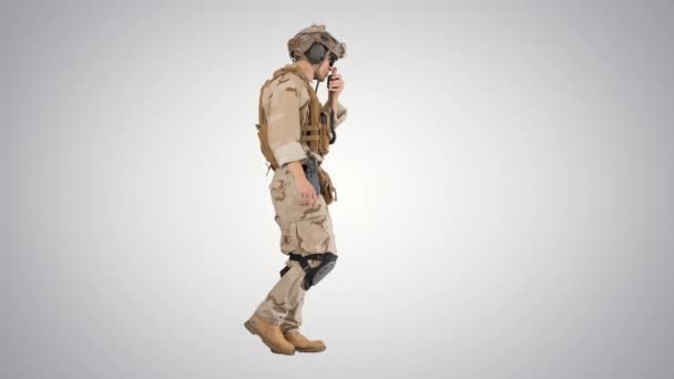 Military man marine walking and using radio on gradient background. — Stock Video