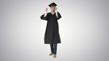 Yüksek lisans öğrencisi diploma tutuyor ve gradyan arka plandaki fotoğraf için onunla poz veriyor..