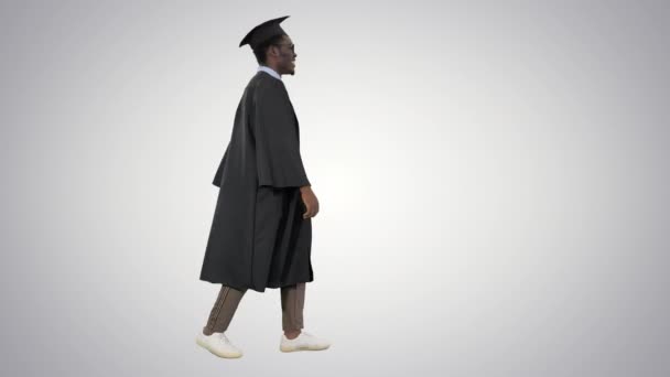 Cheerful african graduate student dancing with diploma on gradient background. — Stock Video