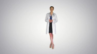 Genç profesyonel kadın doktor steteskop ile üniforma giyer ve gradyan arka planda kamerayla konuşur..