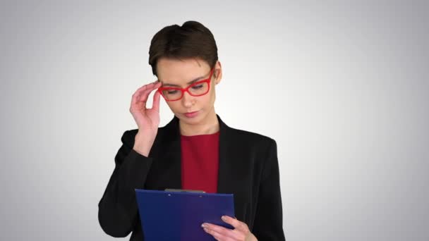 Joven hermosa mujer leyendo documentos sobre el fondo gradiente . — Vídeos de Stock