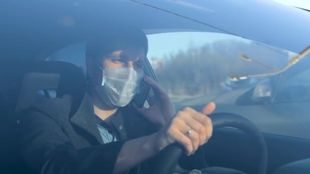 Businessman in medical face mask using mobile phone inside car. — Stock Video