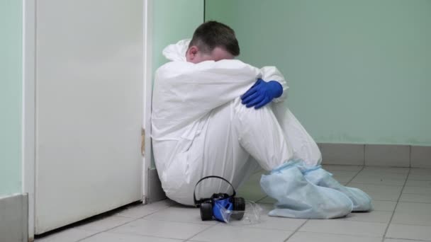 Dottore che si prende una pausa seduto sul pavimento di un ospedale . — Video Stock