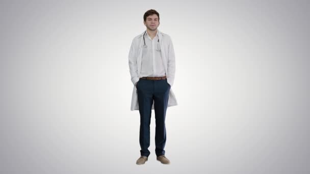 Sad young man doctor shaking had on gradient background. — Stock Video