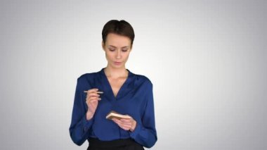 Zeki ve düşünceli genç bir kadın. Kalemle dudaklarını birbirine değdiriyor. Fikir arıyor ve grafiksel arka plana yazıyor..