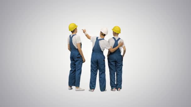 Pracovníci stojící při pohledu na staveniště na skloněném pozadí. — Stock video