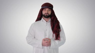 Şeyh keffiyeh giyer, gradyan arka planda hoş geldin jesti yapar..