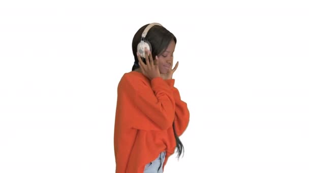 Glad afrikansk kvinna bära trådlösa hörlurar lyssna musik på vit bakgrund. — Stockvideo