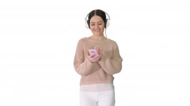 Mutlu kız beyaz arka planda kulaklık takarak müzik dinliyor..