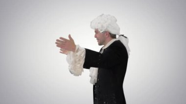 Wolfgang Amadeus Mozart gibi giyinmiş bir adam orkestra yönetiyor..