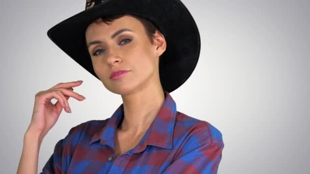 自信のある女性でカウガール帽子見ますへカメラ上のグラデーション背景. — ストック動画