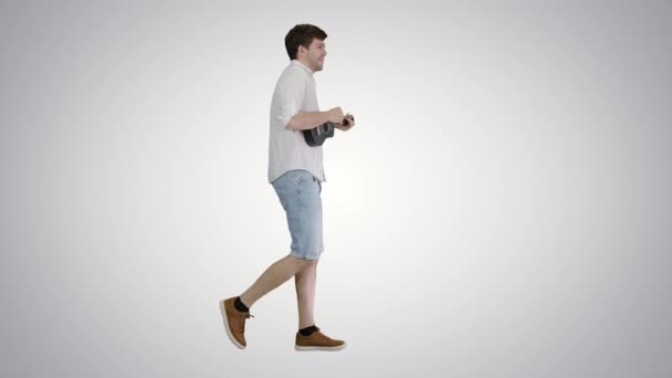 若い男はウクレレを演奏し、歌い、グラデーションの背景を歩く. — ストック動画
