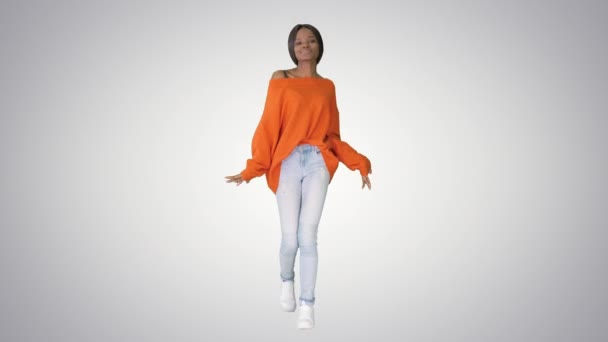 Афроамериканська дівчина танцює на градієнтному фоні. — стокове відео