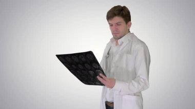 Röntgen görüntüsüne bakan ve kameraya bakan üzgün erkek doktor. Gradyan arka planda yapabileceğimiz bir şey yok..