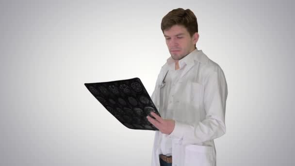 Verontrustende mannelijke arts te kijken naar x-ray MRI beeld en op zoek naar camera, niets wat we kunnen doen op gradiënt achtergrond. — Stockvideo