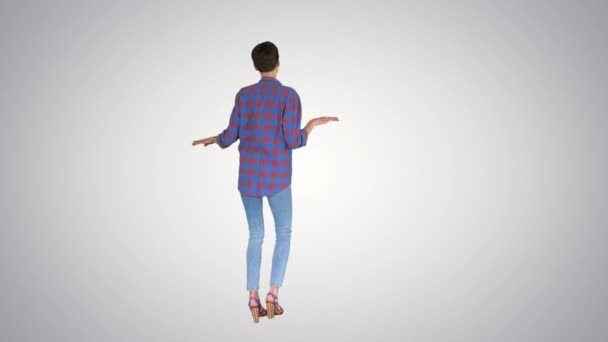 Женщина в повседневной рубашке танцует на градиентном фоне . — стоковое видео