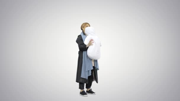 年轻母亲抱着孩子在外面玩，背景是渐变的. — 图库视频影像