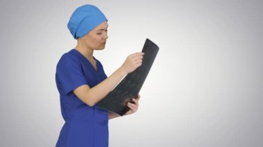 Ciddi bir kadın doktor, arka plandaki beyin MR 'ına bakıyor..