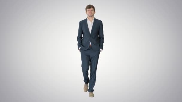 Hombre de negocios guapo caminando hacia adelante en el fondo gradiente . — Vídeos de Stock
