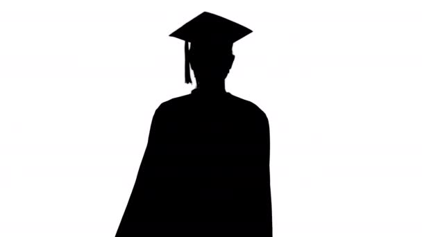 Silhouette Női Végzős Cap and Gown Viselő orvosi maszk Walking. — Stock videók