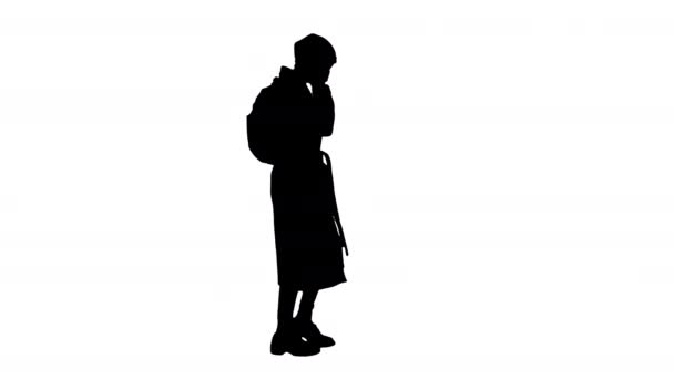의료용 마스크를 쓴 실루엣 여성걷다가 누군가에게 전화를 하는 모습. — 비디오