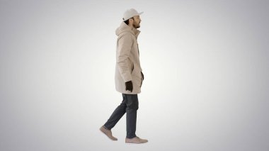 Kış modasına uygun ceketli yakışıklı bir adam gradyan arka planda yürüyor..