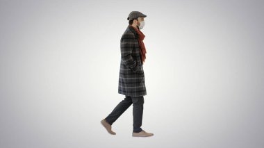 Koruyucu bir yüz maskesi takan beyefendi, arka planda yürüyor..