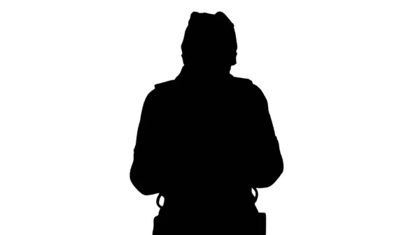 Силуэт Женщина одета в пальто носить медицинскую маску с помощью телефона и ходьбы . — стоковое фото
