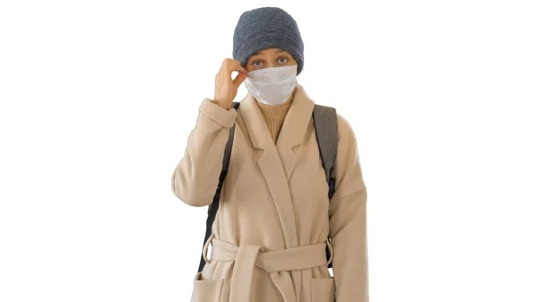 Chica en una mascarilla médica de pie en un abrigo sobre fondo blanco . —  Fotos de Stock