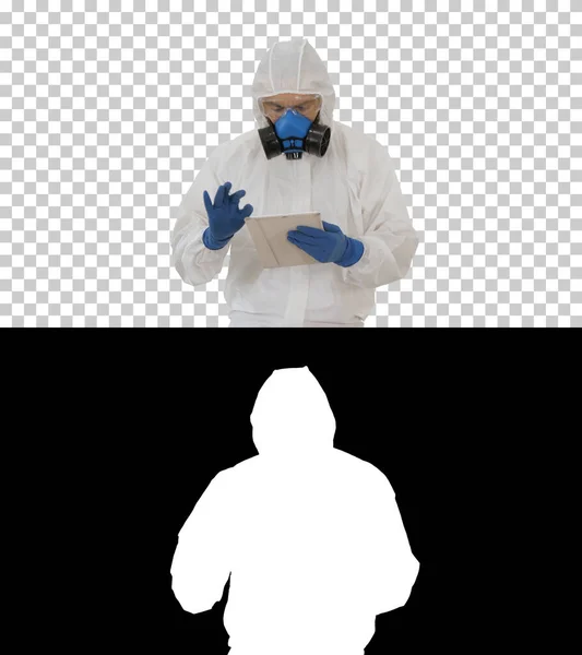 Эпидемиолог в защитном костюме и респираторной маске с помощью цифрового планшета во время ходьбы, Альфа-канал — стоковое фото