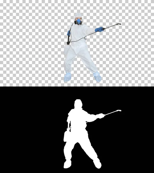 NBC özel koruma ekipmanı giyen bir adam dezenfektan sıkar ve dans eder, Alpha Channel — Stok fotoğraf