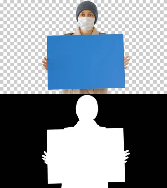 Γυναίκα με εξωτερικά ρούχα και με ιατρική μάσκα κρατώντας κενό πίνακα, Alpha Channel — Φωτογραφία Αρχείου
