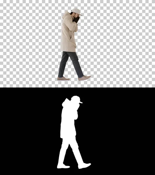 Caucasian man in a hat and coat coughing walking, Alpha Channel