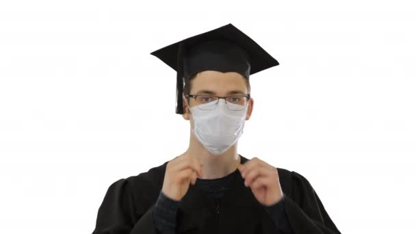Étudiant diplômé en masque médical sur fond blanc . — Video